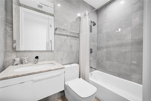 full bathroom with tile walls, backsplash, vanity, toilet, and shower / bath combo