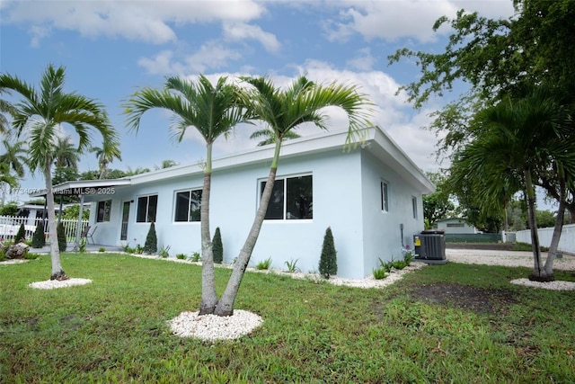 view of side of property with cooling unit and a yard