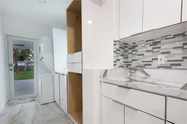 kitchen featuring white cabinetry, light stone countertops, and backsplash