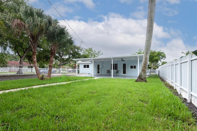 rear view of property featuring a patio area, ceiling fan, and a lawn