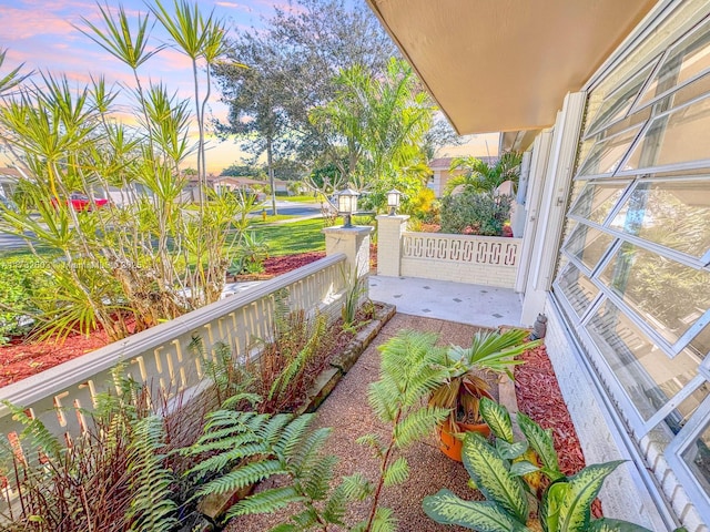 balcony at dusk featuring a porch