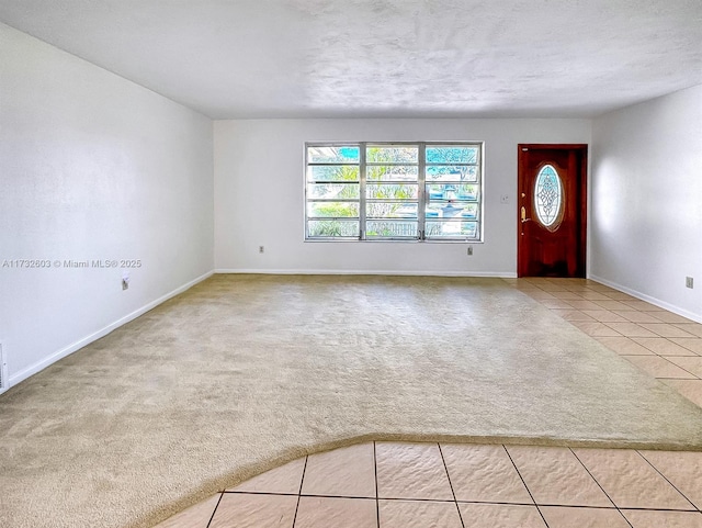 entryway with light colored carpet and a textured ceiling