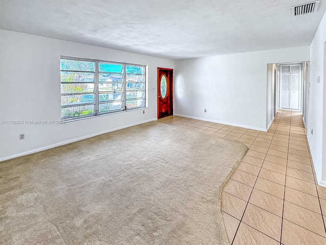 empty room featuring light tile patterned flooring and a textured ceiling