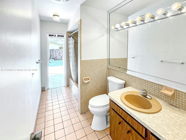 full bathroom with shower / tub combo with curtain, tile patterned floors, toilet, tile walls, and vanity