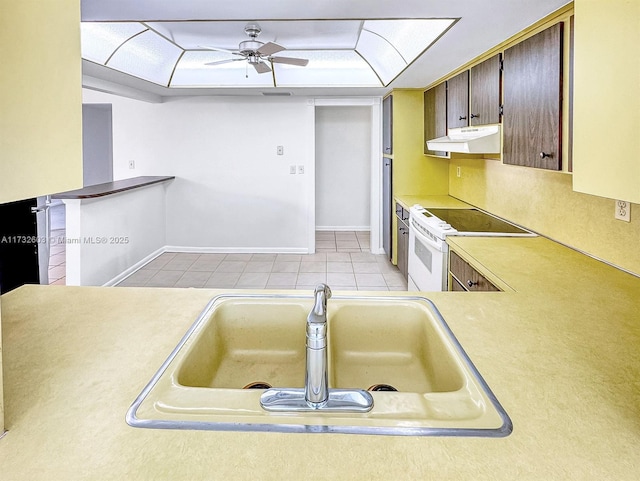 kitchen with a tray ceiling, sink, electric range, and light tile patterned floors