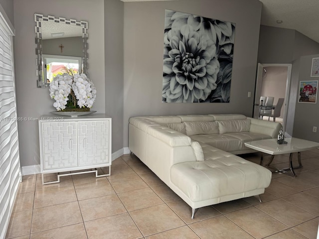 living room with lofted ceiling and light tile patterned floors