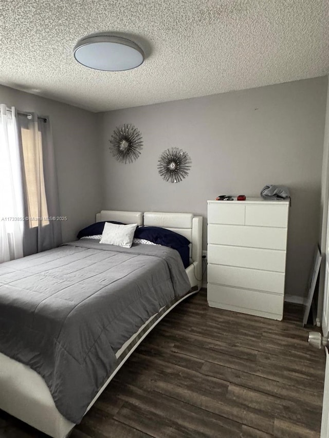 bedroom with dark wood-type flooring and a textured ceiling