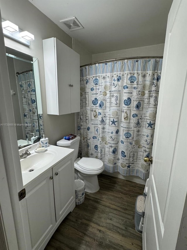 bathroom with vanity, hardwood / wood-style floors, toilet, and walk in shower