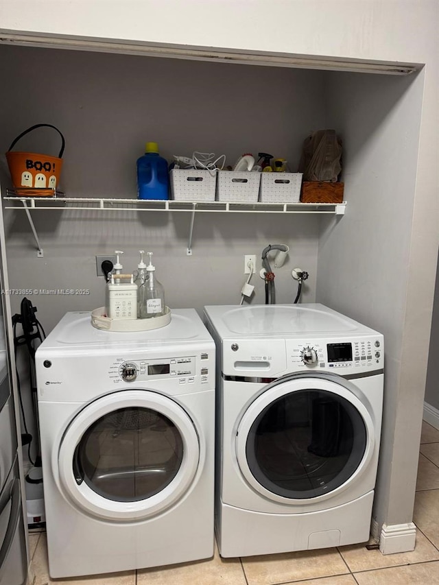 laundry room featuring light tile patterned flooring and separate washer and dryer