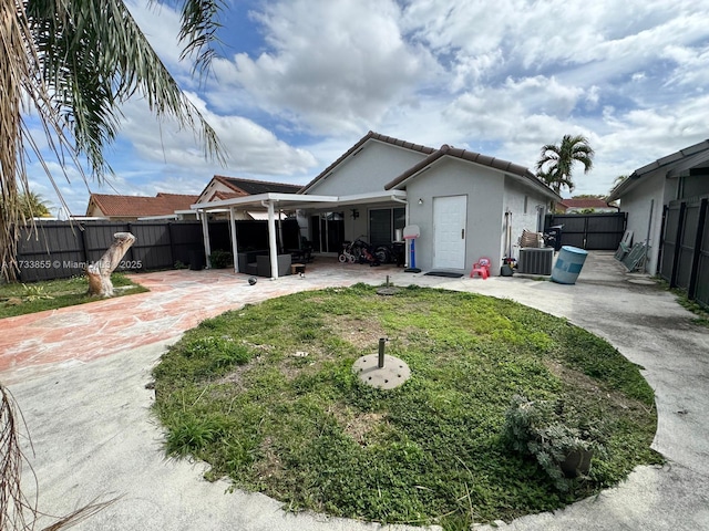 back of property with a yard, a patio area, and central air condition unit