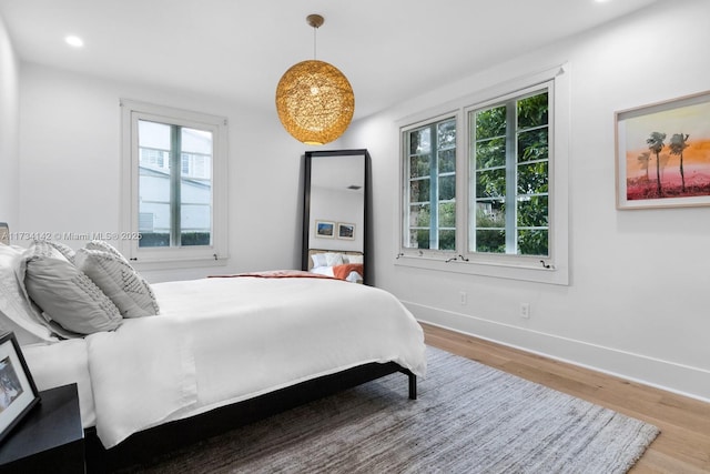 bedroom featuring multiple windows and hardwood / wood-style flooring