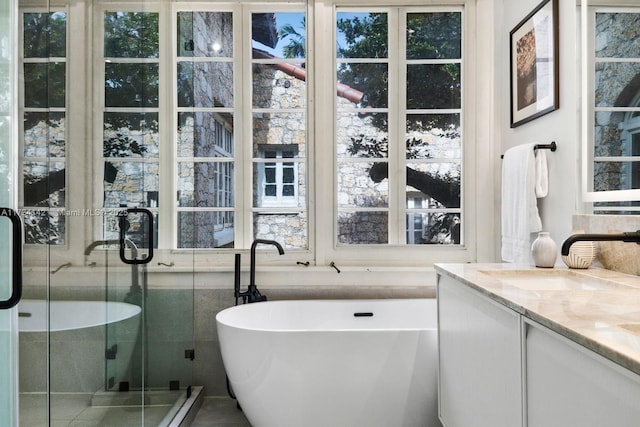 bathroom featuring vanity and independent shower and bath