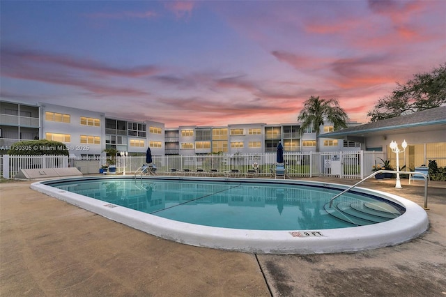 pool at dusk with a patio