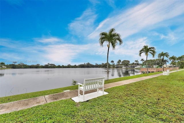 view of dock featuring a water view and a yard