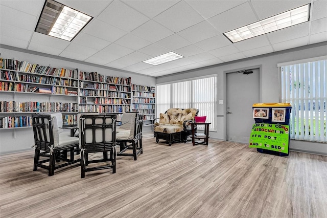 interior space with wood-type flooring, a healthy amount of sunlight, and a paneled ceiling