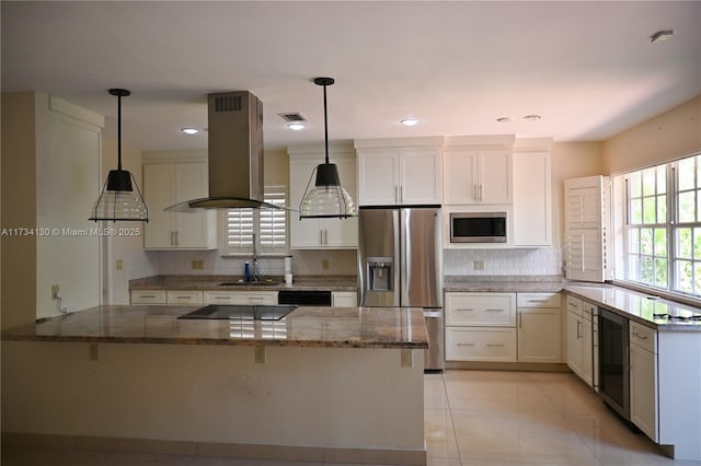 kitchen with hanging light fixtures, black appliances, white cabinets, island exhaust hood, and dark stone counters