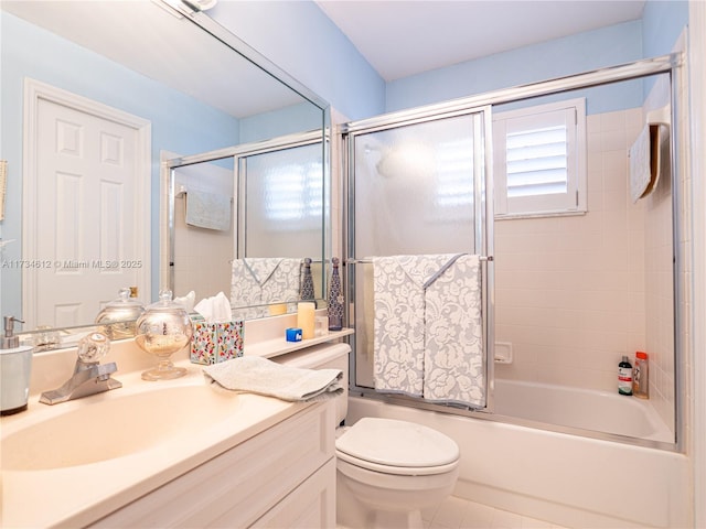 full bathroom with tile patterned flooring, vanity, bath / shower combo with glass door, and toilet