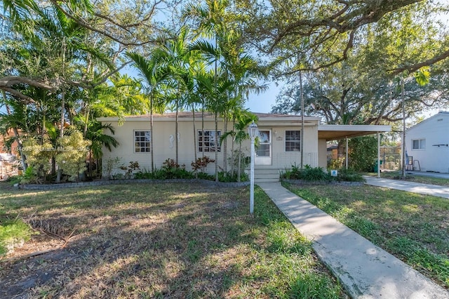 ranch-style home with a carport and a front yard