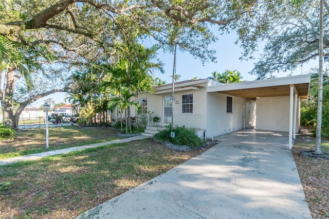 view of front of property featuring a carport and a front lawn