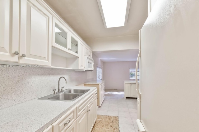 kitchen featuring sink, white appliances, and white cabinets