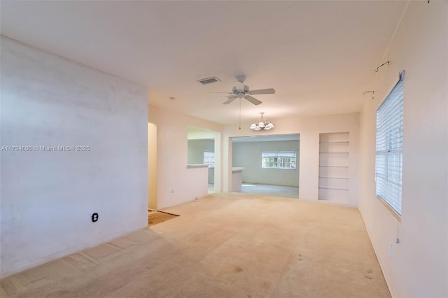 carpeted empty room featuring built in features and ceiling fan