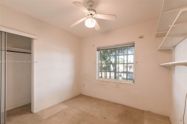 unfurnished bedroom featuring light colored carpet, a closet, and ceiling fan