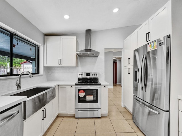 kitchen featuring white cabinets, appliances with stainless steel finishes, sink, and wall chimney range hood