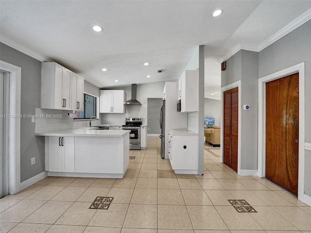 kitchen with sink, white cabinets, kitchen peninsula, stainless steel appliances, and wall chimney range hood