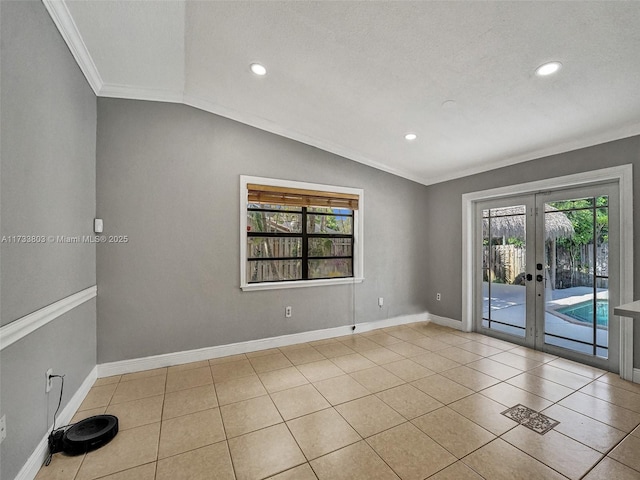 spare room with french doors, lofted ceiling, crown molding, and light tile patterned floors