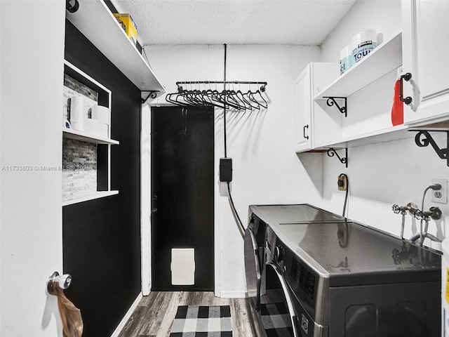 laundry area with cabinets, dark hardwood / wood-style flooring, separate washer and dryer, and a textured ceiling