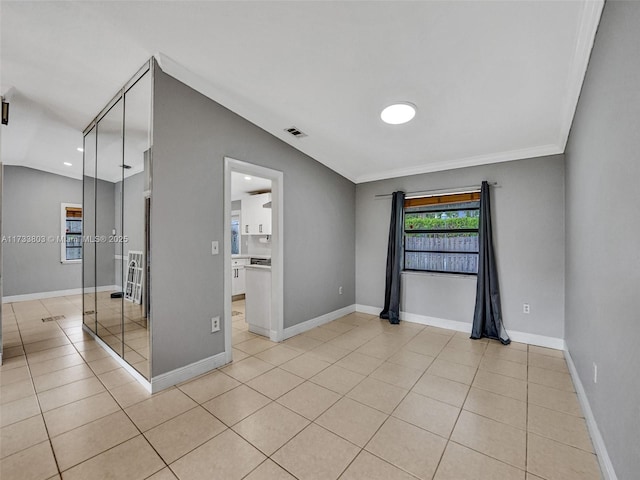 empty room featuring light tile patterned floors and vaulted ceiling