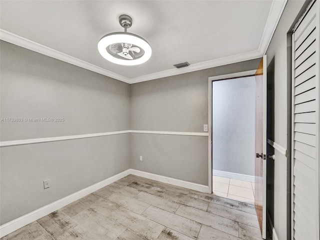 empty room with ornamental molding and light hardwood / wood-style flooring