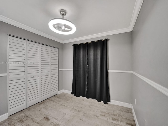 unfurnished bedroom with crown molding, a closet, and light hardwood / wood-style flooring