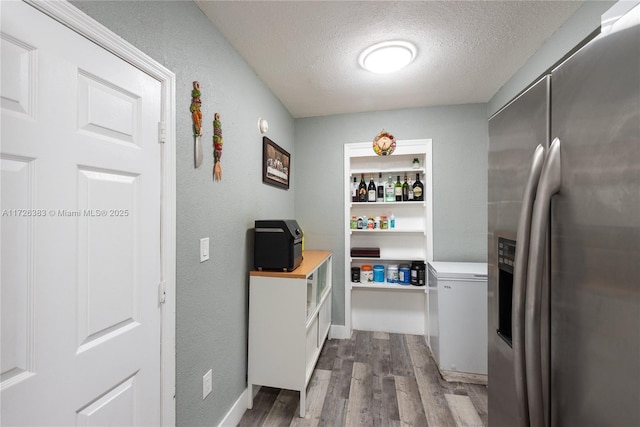 hallway featuring hardwood / wood-style floors and a textured ceiling