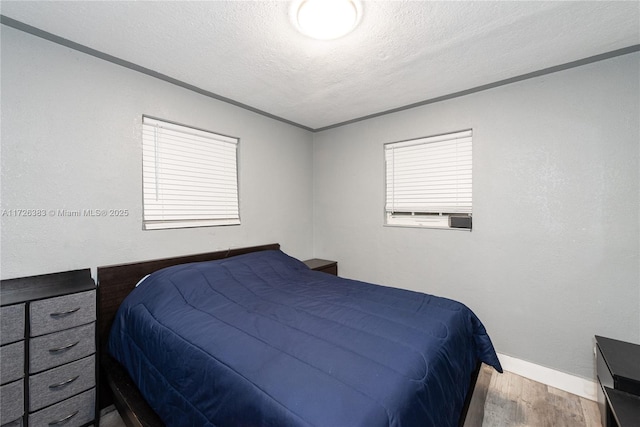 bedroom featuring hardwood / wood-style floors and a textured ceiling