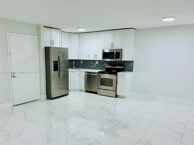 kitchen with stainless steel appliances, sink, white cabinets, and decorative backsplash