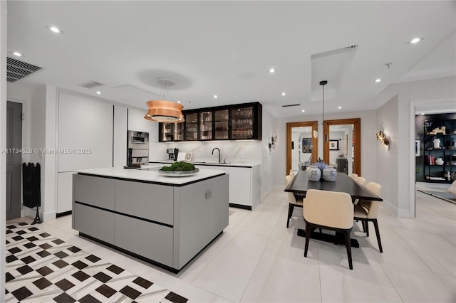 kitchen featuring double oven, hanging light fixtures, and a kitchen island