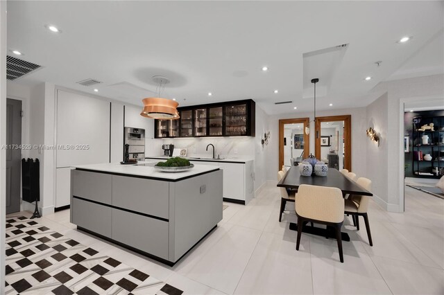 3400 SW 27th Ave Unit 704, Miami, FL 33133 - kitchen with a kitchen island, glass insert cabinets, hanging light fixtures, stainless steel double oven, and recessed lighting