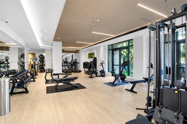 exercise room with expansive windows and light hardwood / wood-style floors