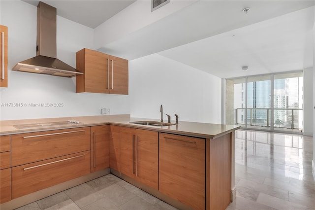 kitchen featuring floor to ceiling windows, sink, electric cooktop, kitchen peninsula, and exhaust hood