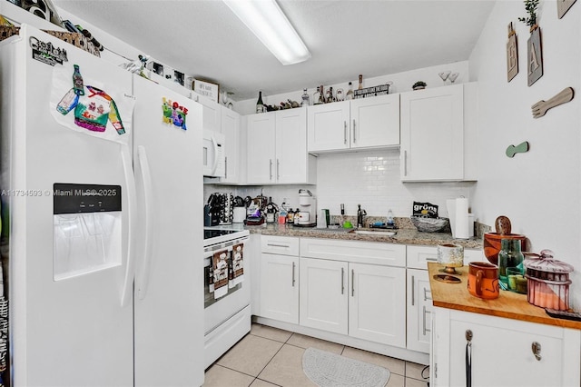 kitchen with light tile patterned flooring, sink, white cabinets, and white appliances