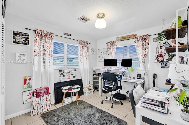 home office featuring light tile patterned floors and a textured ceiling