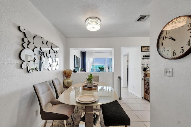 dining area with light tile patterned floors and a textured ceiling