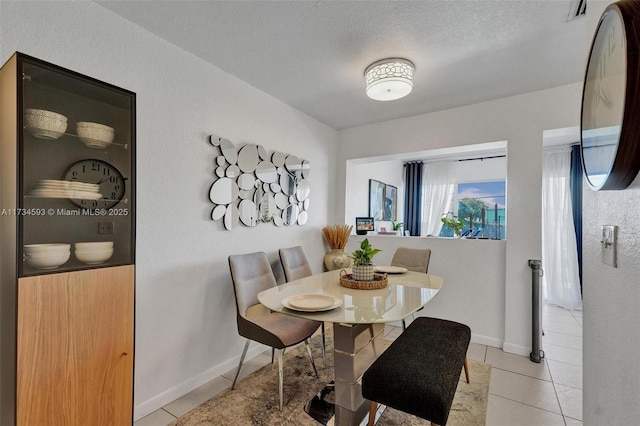 dining area with light tile patterned flooring and a textured ceiling