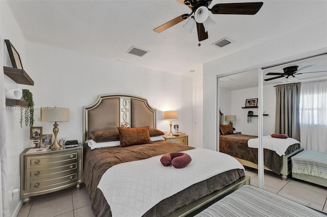 tiled bedroom with ceiling fan and a closet