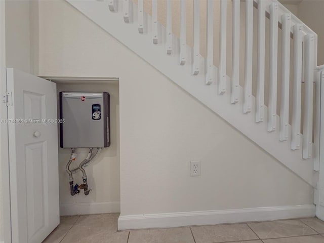 stairs featuring tile patterned flooring and water heater