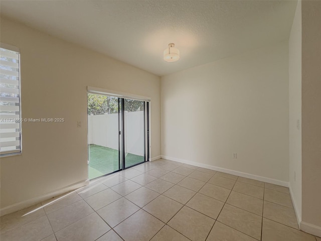 spare room with light tile patterned floors and a textured ceiling