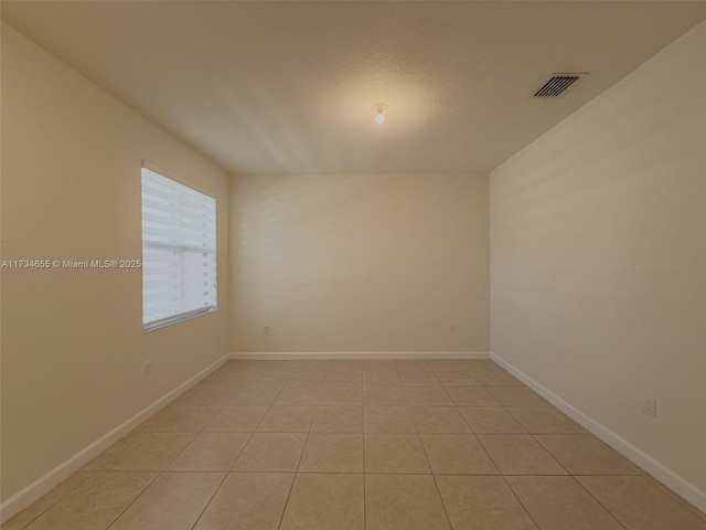 unfurnished room featuring light tile patterned flooring and a textured ceiling