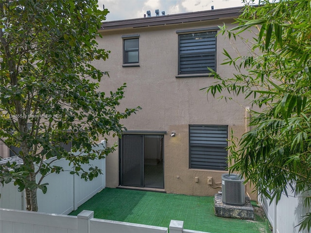 rear view of house with a yard and central air condition unit