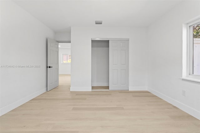 unfurnished bedroom with a closet and light hardwood / wood-style flooring